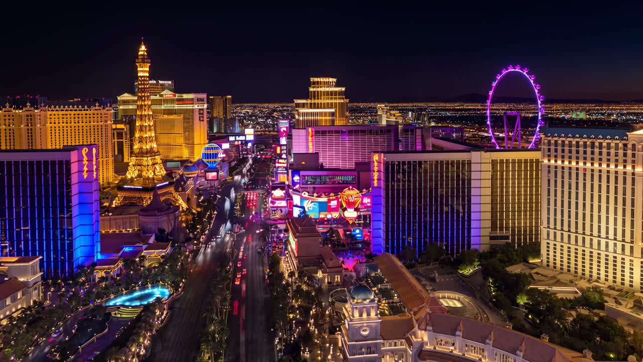 Aerial video shot of a vibrant cityscape at night, showcasing colorful lights and bustling streets