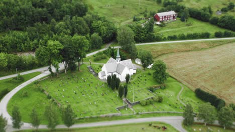 an aerial view of a beautiful miniature cross-shaped church with a sophisticated narrow bell tower