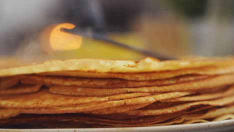 anonymous cook putting a pancake on top of another pancake