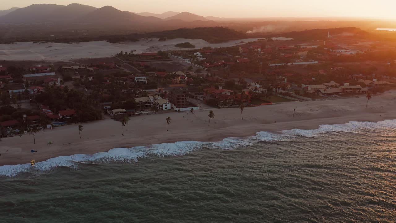 Aerial view of a beach with mountains and sand dunes at sunset