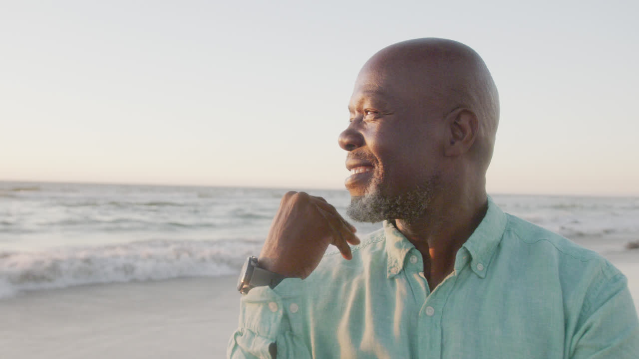 Happy senior african american woman smiling at beach, in slow motion