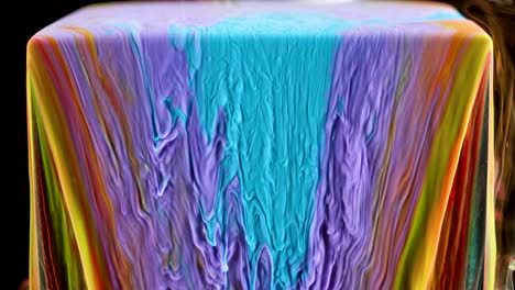 multicolored ink paint slowly flows from the cube underwater