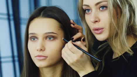 makeup artist young woman's make up in a studio 8