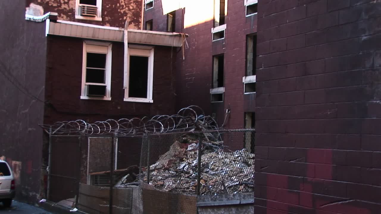 사이클론 울타리와 철조망은 원치 않는 방문자가 버려진 건물의 창문에 있는 에어컨에 접근하는 것을 방지해야 합니다.