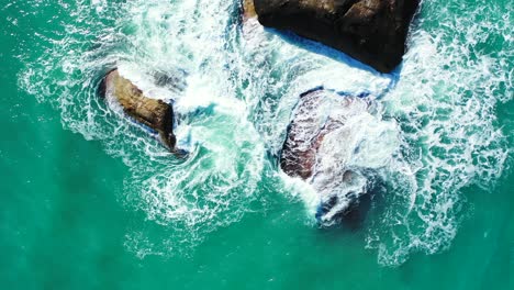 Sea-scenery-with-white-waves-crushing-on-limestone-cliffs-in-the-middle-of-turquoise-lagoon-near-coastline-of-Myanmar