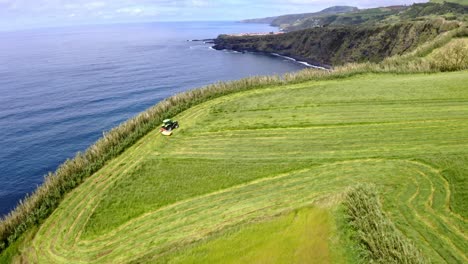 Tractor-Cortando-Hierba-De-Campo-En-Los-Acantilados-De-La-Costa-Del-Mar-De-Azores,-Paso-Elevado