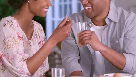 pareja sonriente tomando el desayuno juntos