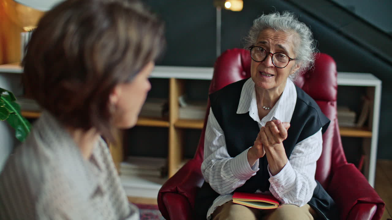 Elderly Therapist Speaking Empathetically to Woman during Consultation