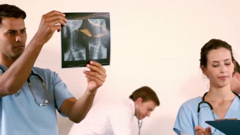 Medical-team-talking-while-nurse-looking-X-ray