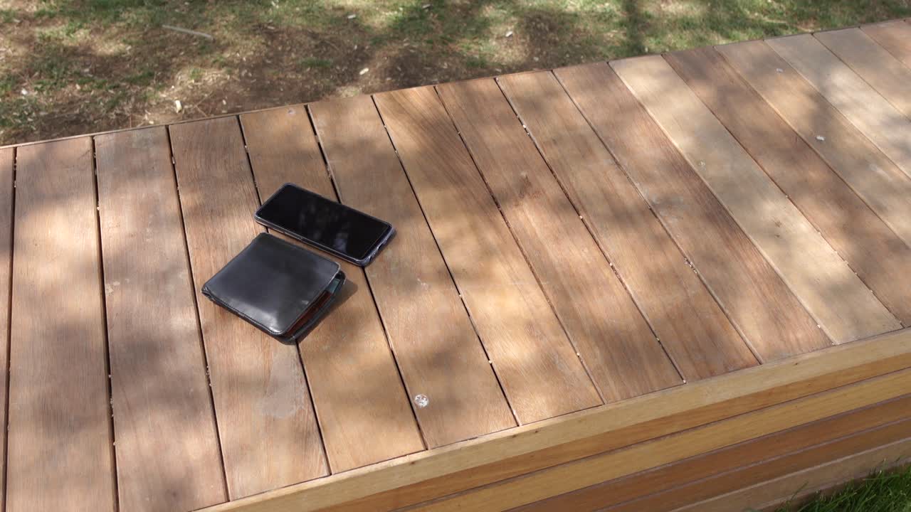 teléfono y billetera en un banco de madera