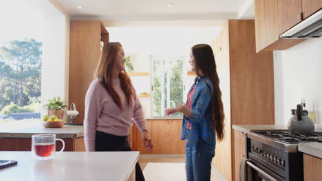 dancing together, asian mother and daughter enjoying time in modern kitchen