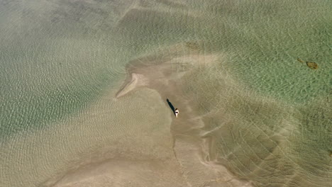 Einsame-Frau,-Die-Auf-Dem-Flachen-Wasser-Des-Elafonissi-strandes-In-Griechenland-Geht