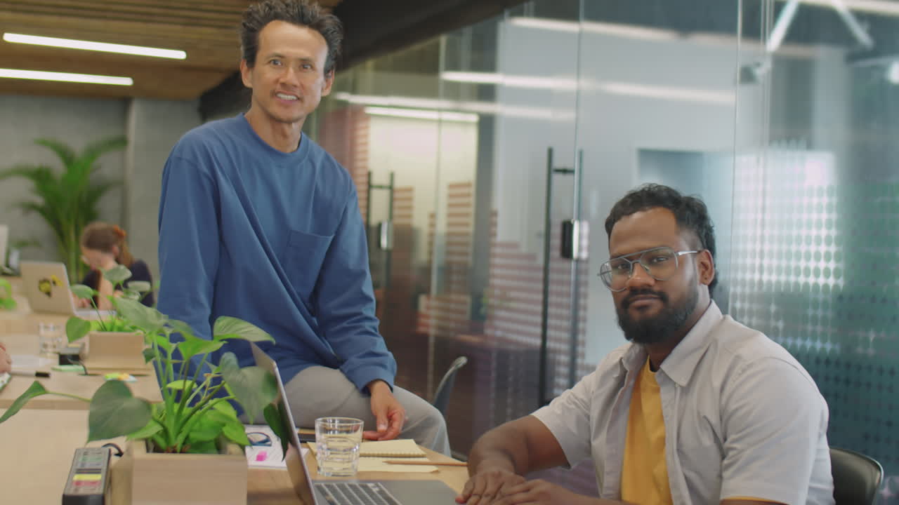 Portrait of Two Multi-Ethnic Male Colleagues in Coworking Room