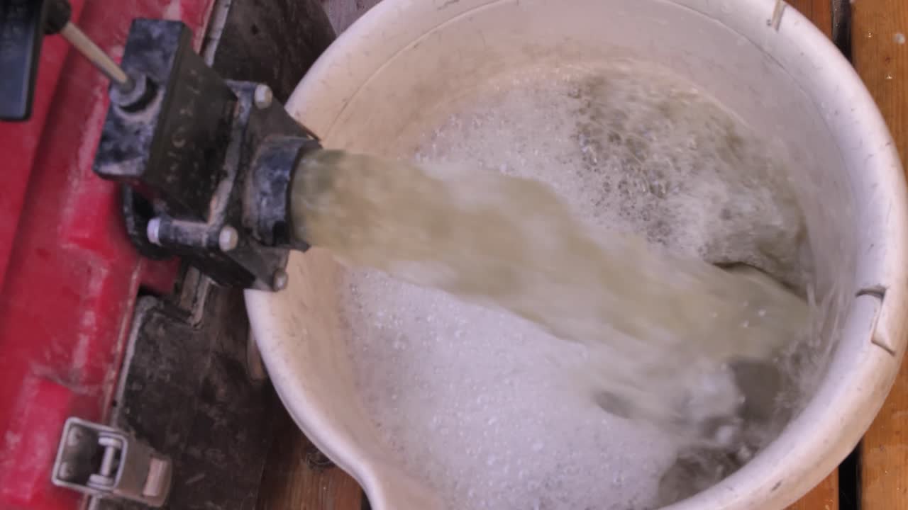 verter agua al balde del tanque de agua de lluvia en el jardín, cerrar