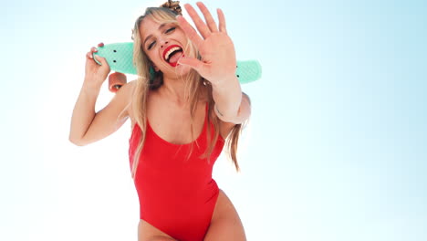 woman in a red swimsuit with a teal skateboard