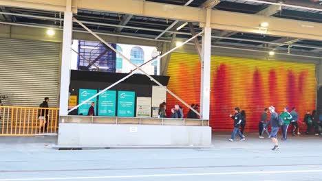 pedestrians pass vibrant mural in melbourne, australia