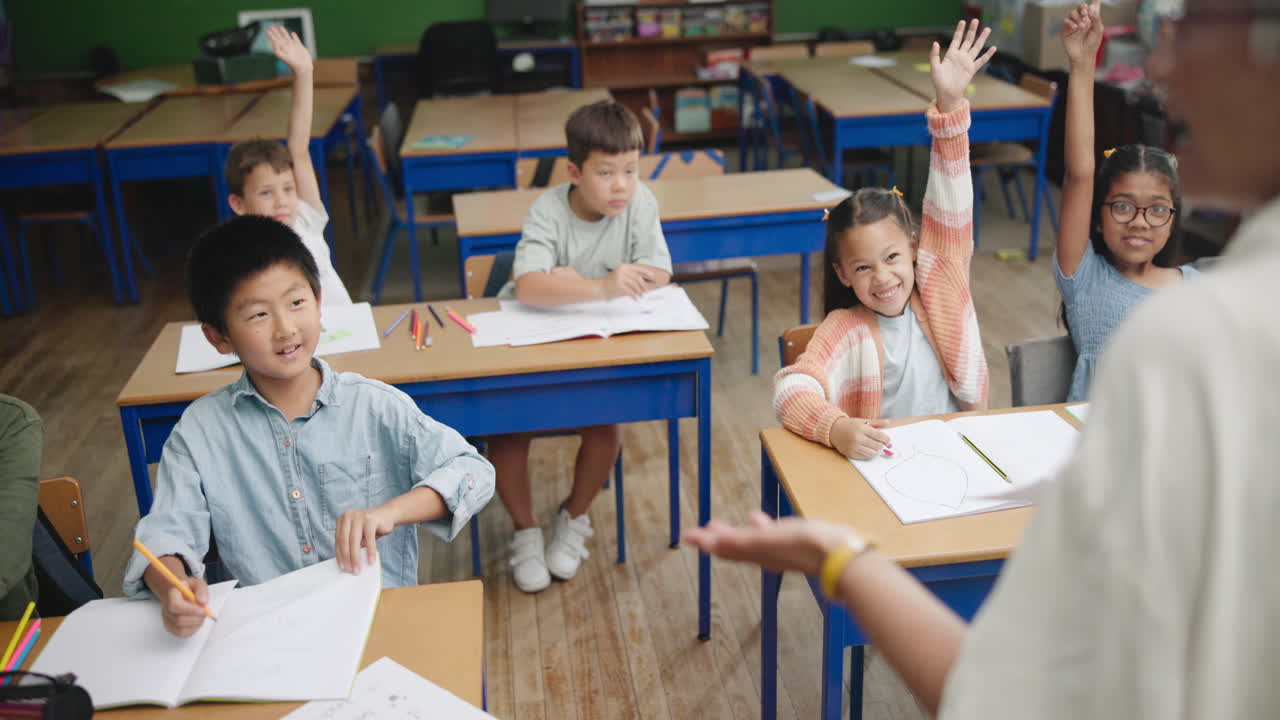 Students raising hands in the classroom