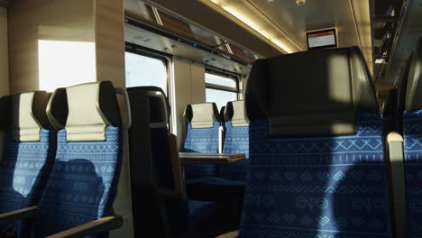 view of train seats reflecting the sun path and shadow move projected through the carriage windows - medium close-up static shot