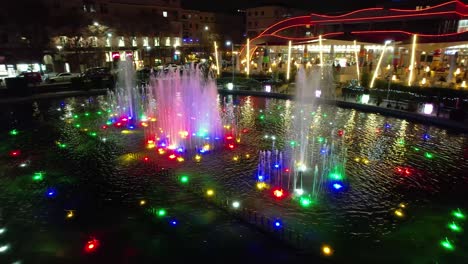 una fuente de colores bellamente iluminada por la noche refleja el ambiente de un lugar relajante en tirana, la capital de albania