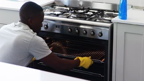 man cleaning the oven in kitchen