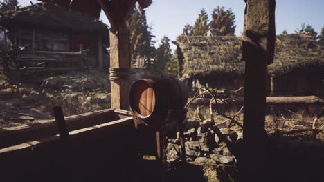 wooden barrel and rustic huts in a tranquil outdoor setting during daylight