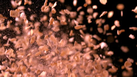 copos de avena rebotando contra un fondo negro