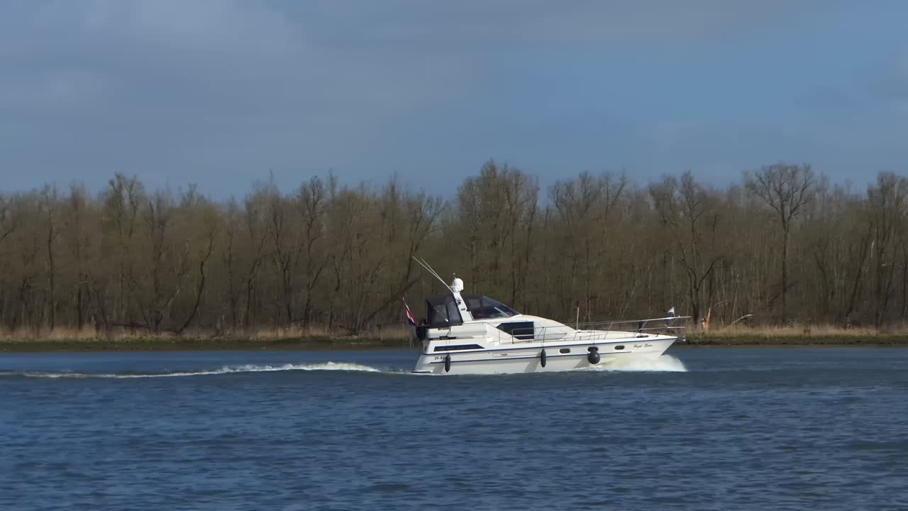 Luxury motor yacht sails on the river. View from the side