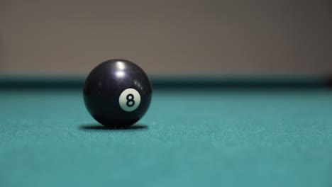 black 8-ball spinning to a stop on a billiards table