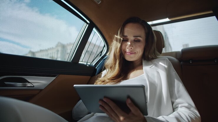 Donna d'affari sorridente che lavora con un tablet