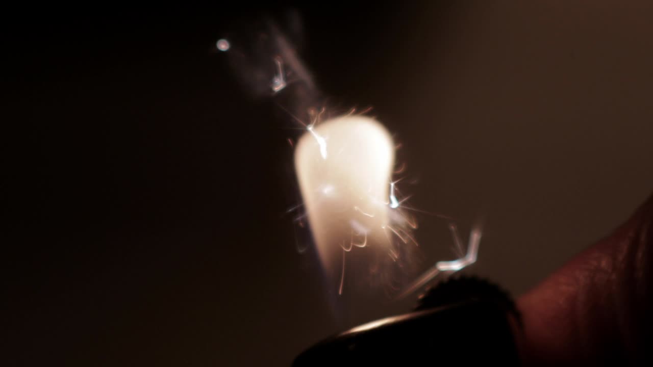 손은 검은 바탕에 라이터를 켜고 있습니다.