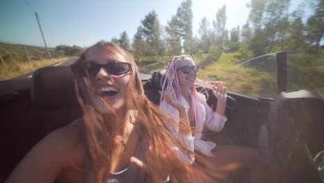 friends enjoying a sunny convertible road trip