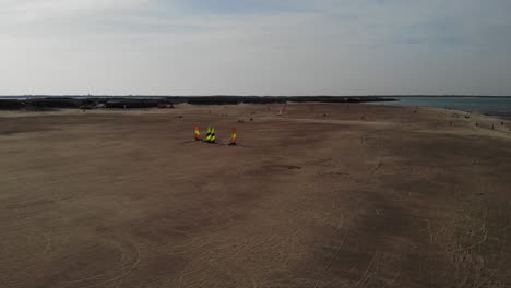 aerial view of people participates on land sailing competition at sandy beach of brouwersdam, netherlands