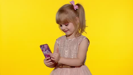 Child-girl-using-smartphone.-Portrait-of-blonde-kid-emotionally-makes-selfie-on-mobile-phone