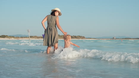 Glückliches-Mädchen-Mit-Sohn,-Der-An-Der-Küste-Spielt.-Baby-Junge-Mit-Mutter-Geht-Zum-Wasser.