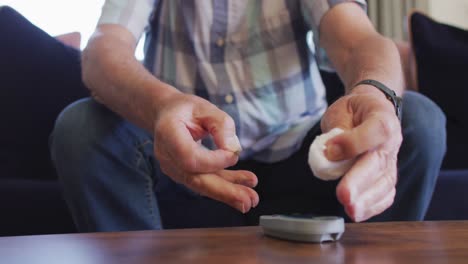 video de las manos de un anciano caucásico enfocado comprobando el nivel de glucosa