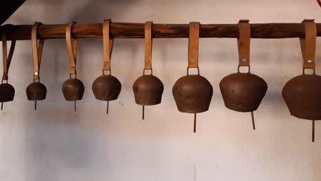 bulgarian cowbells arranged in size and hung on a stick on the wall