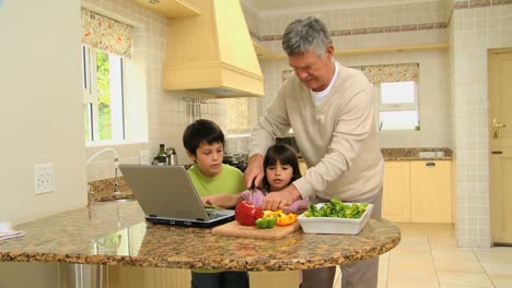 man teaching his grandchildren how to cook