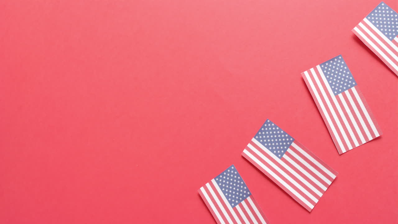 Quattro bandiere nazionali degli USA adagiate su sfondo rosso con spazio per il testo