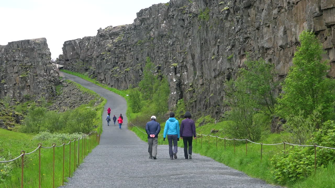 관광객들은 thingvellir iceland에서 대서양 중부 능선을 걷고 있습니다.