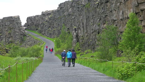 los turistas caminan a través de la dorsal mesoatlántica en thingvellir islandia