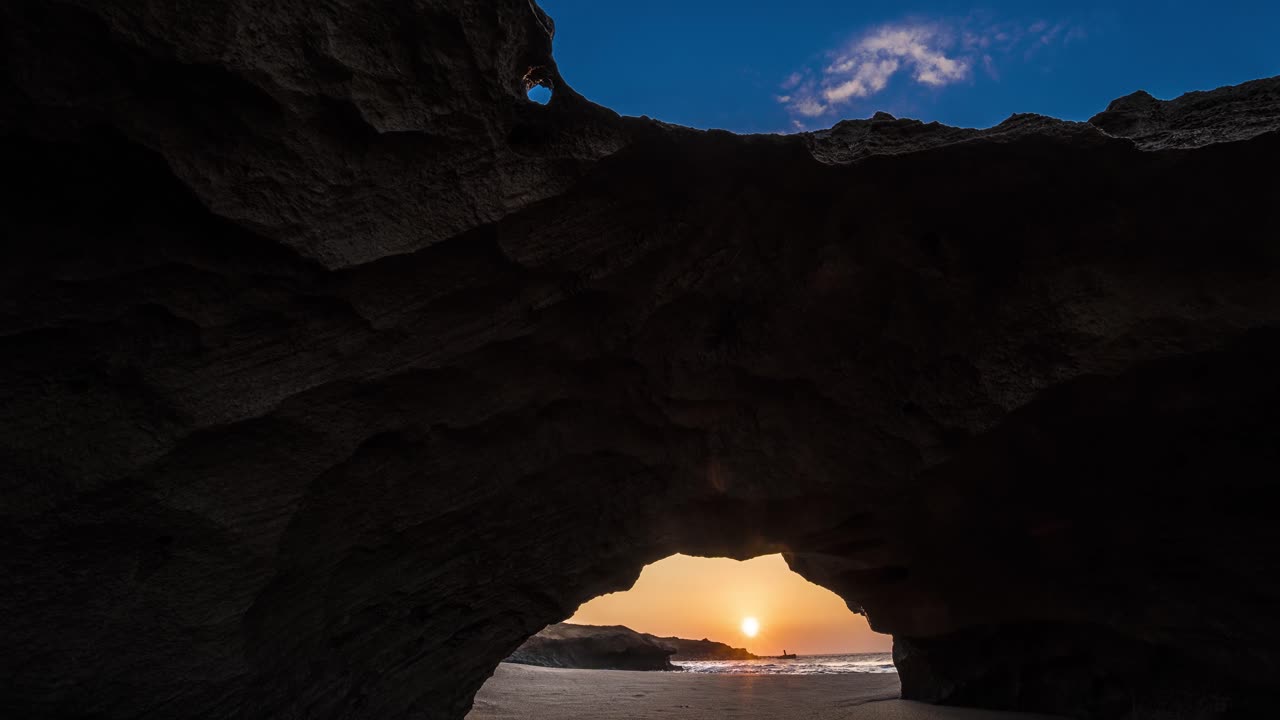 un lapso de tiempo detrás de un arco en una playa tropical en la isla de molokai hawaii