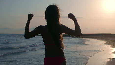 focused woman training at sand beach. pretty girl doing exercises at coastline.