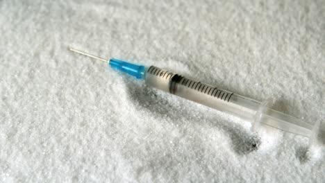 syringe falling into pile of sugar