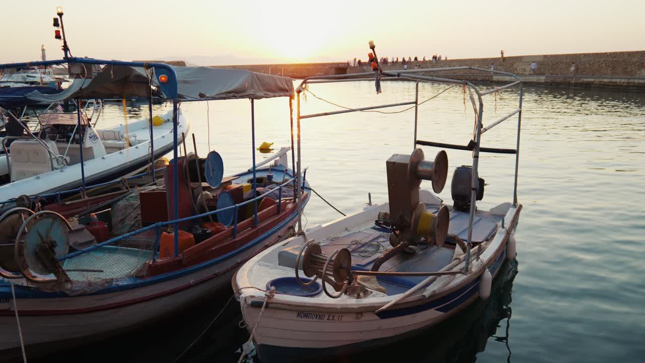Lenta inquadratura rivelatrice del Vecchio Porto Veneziano di Chania con faro storico e splendide acque blu del mare durante il tramonto