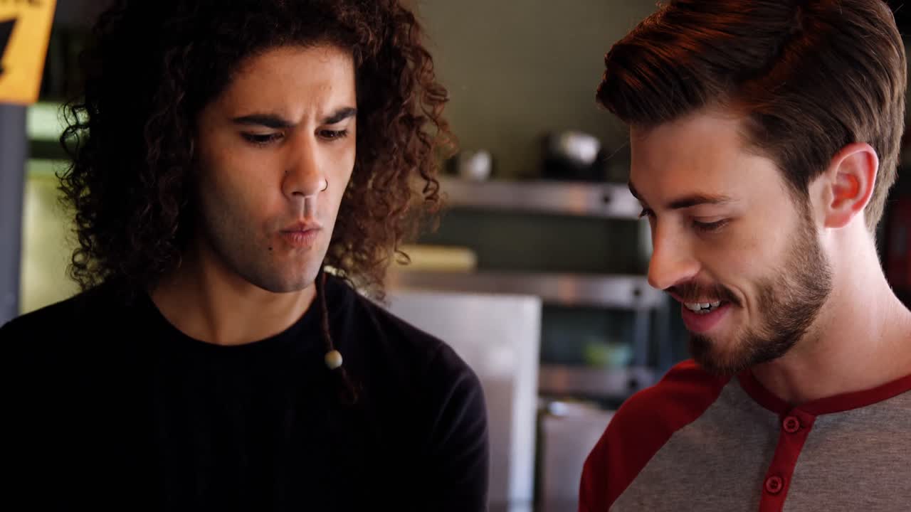 dos hombres interactuando entre sí mientras usan una tableta digital