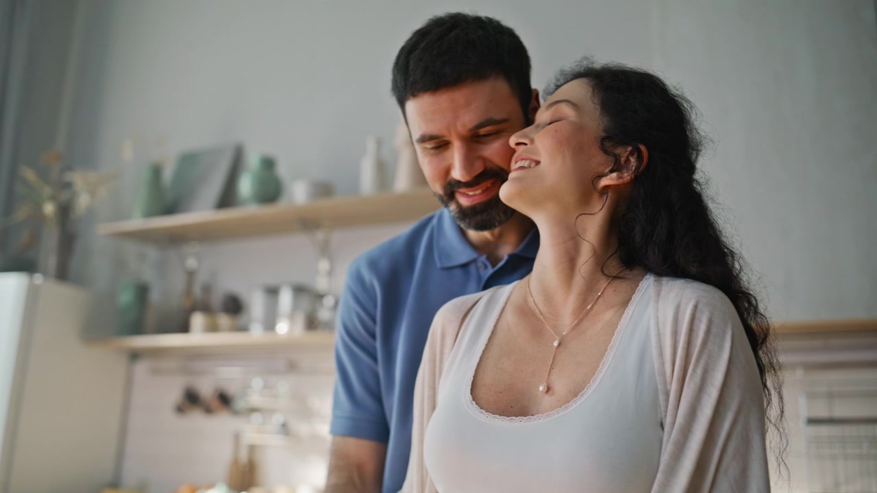 Mulher grávida fatiando repolho na cozinha de casa. Casal cozinhando junto