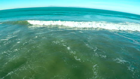 una antena sobre el océano con olas y surf rompiendo