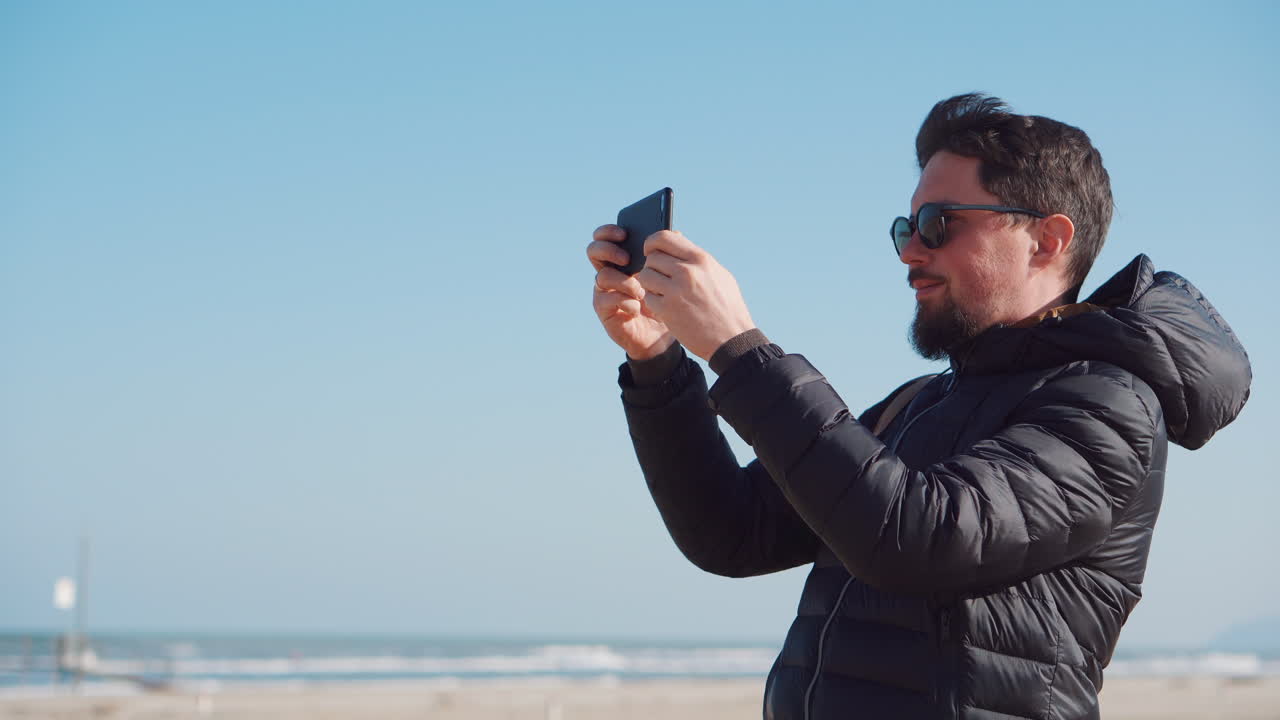 해변에서 사진을 찍는 남자