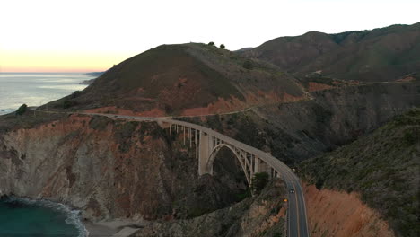 Lone-car-travels-along-highway-1-in-Big-Sur,-crossing-the-Bixby-Bridge