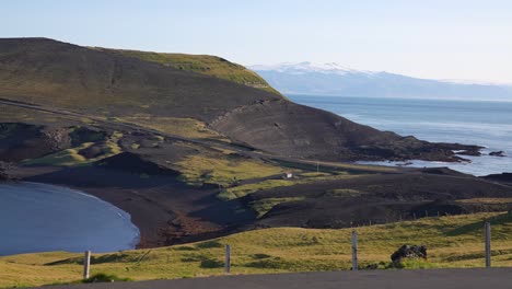 scenic coastline and green pastures of heimaey, westman islands, iceland on sunny summer day